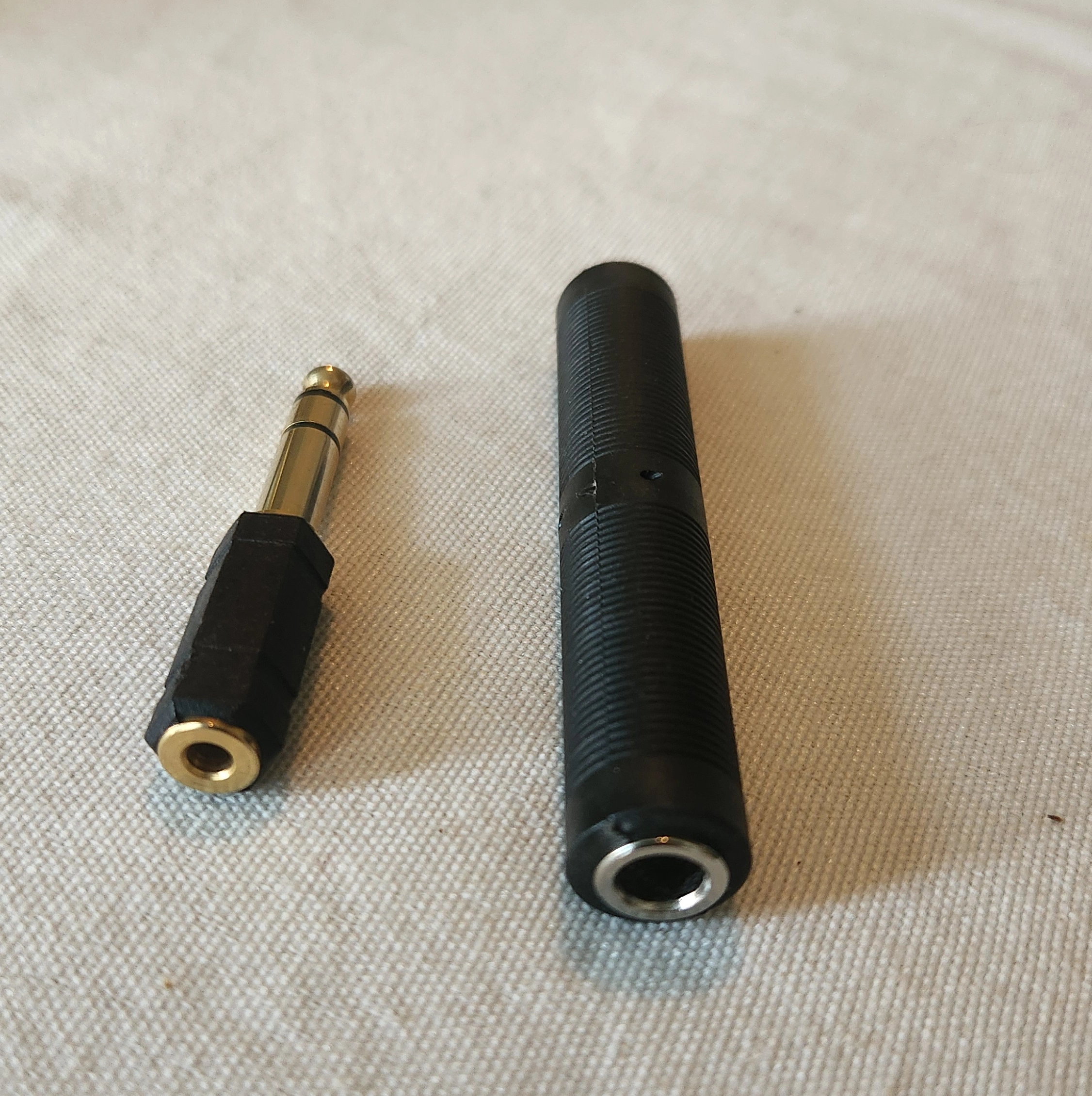 Angle view of the components for a stereo 1/4" female to stereo 1/8" female adapter